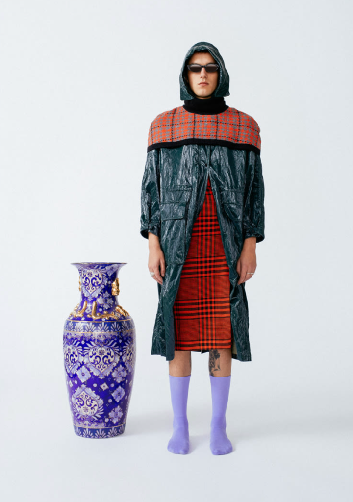 A man wearing a futuristic outfit and lavender Socksss nearly up to his knees