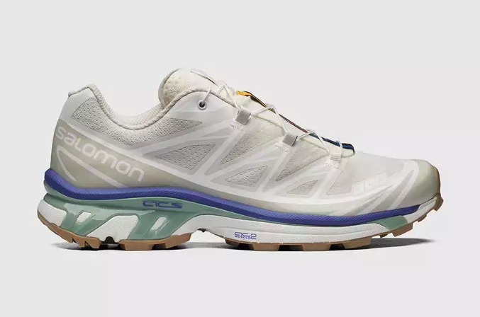 A white pair of Salomon Xt-6 shoes with purple and green details