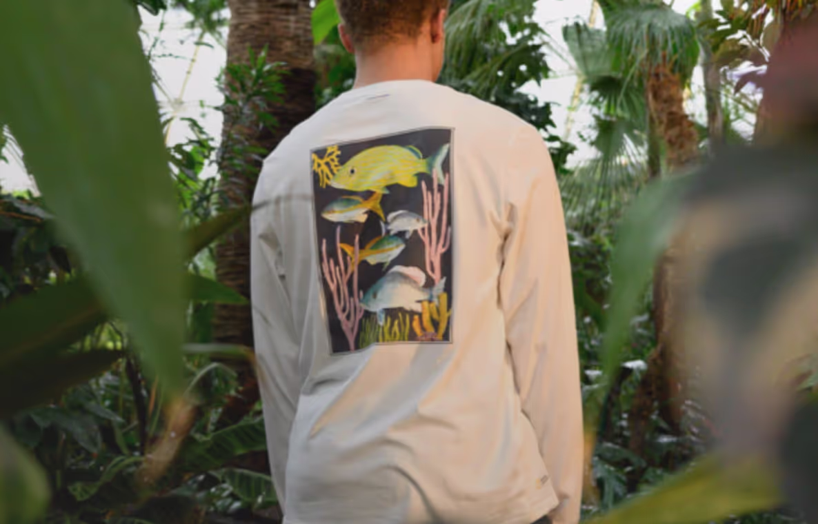 Man in nature wearing white long-sleeve Tentree T-shirt with a Fish print on the back