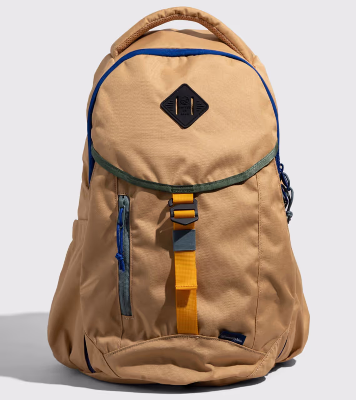 A beige United By Blue backpack with dark blue features on a white background