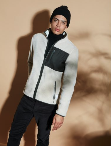 A man wearing a ArmedAngles fleece with a black beanie