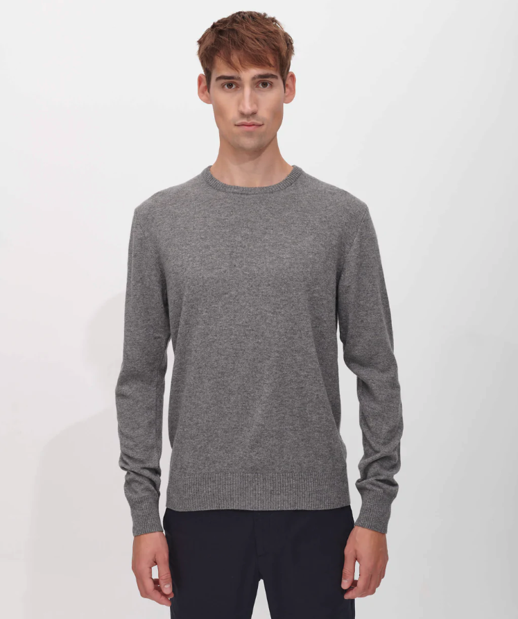 A man wearing a SANVT grey long-sleeve and dark navy blue pants