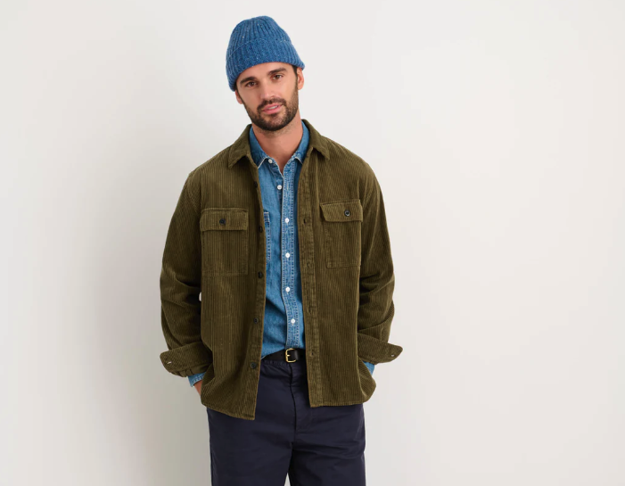 A man wearing a Alex Mill oliver green button up with a blue beanie and navy blue pants