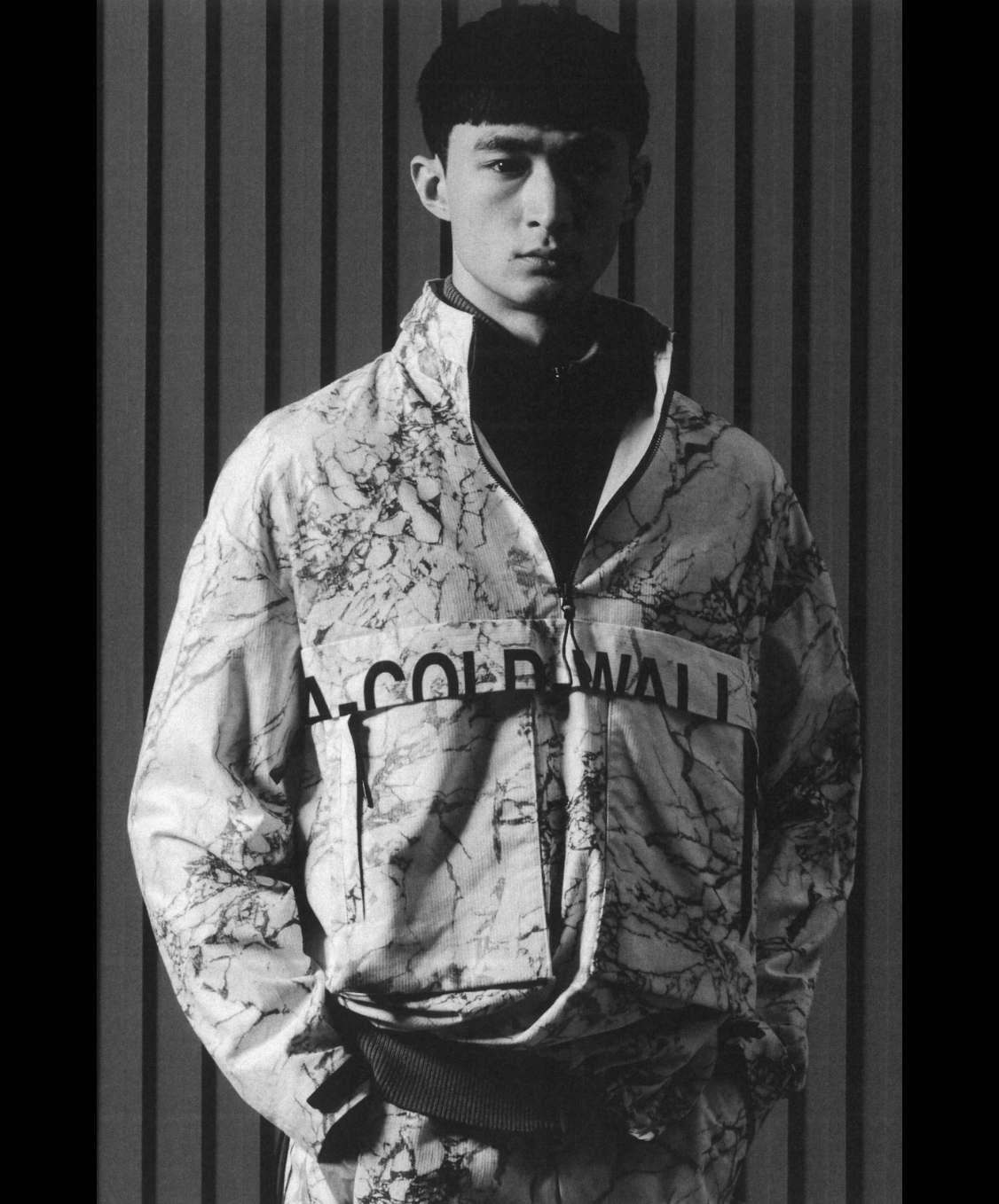 A man wearing a camo-styled A-COLD-WALL jacket with matching pants and a black fleece underneath
