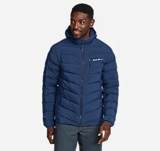 A man wearing a navy blue Eddie Bauer down a jacket with jeans