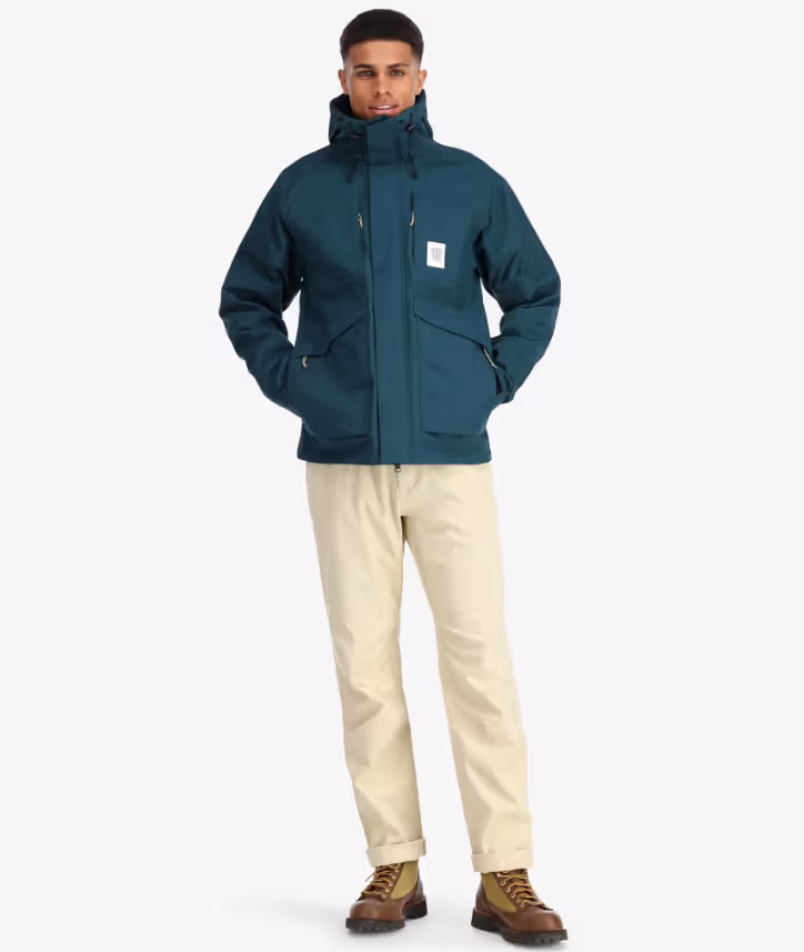 A man wearing a Teal Topo Designs Winter Jacket with Khaki pants and Danner boots