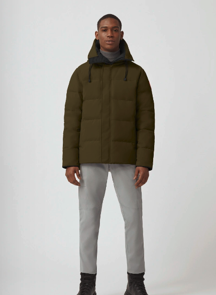 A man wearing an olive Canada Goose down jacket and grey pants