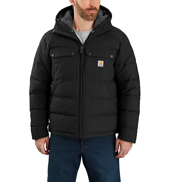 A man wearing a heavy-duty Carhartt black jacket and blue jeans