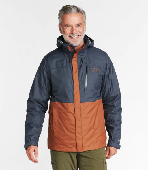 A man wearing a brown and navy blue LL Bean winter jacket and olive green pants