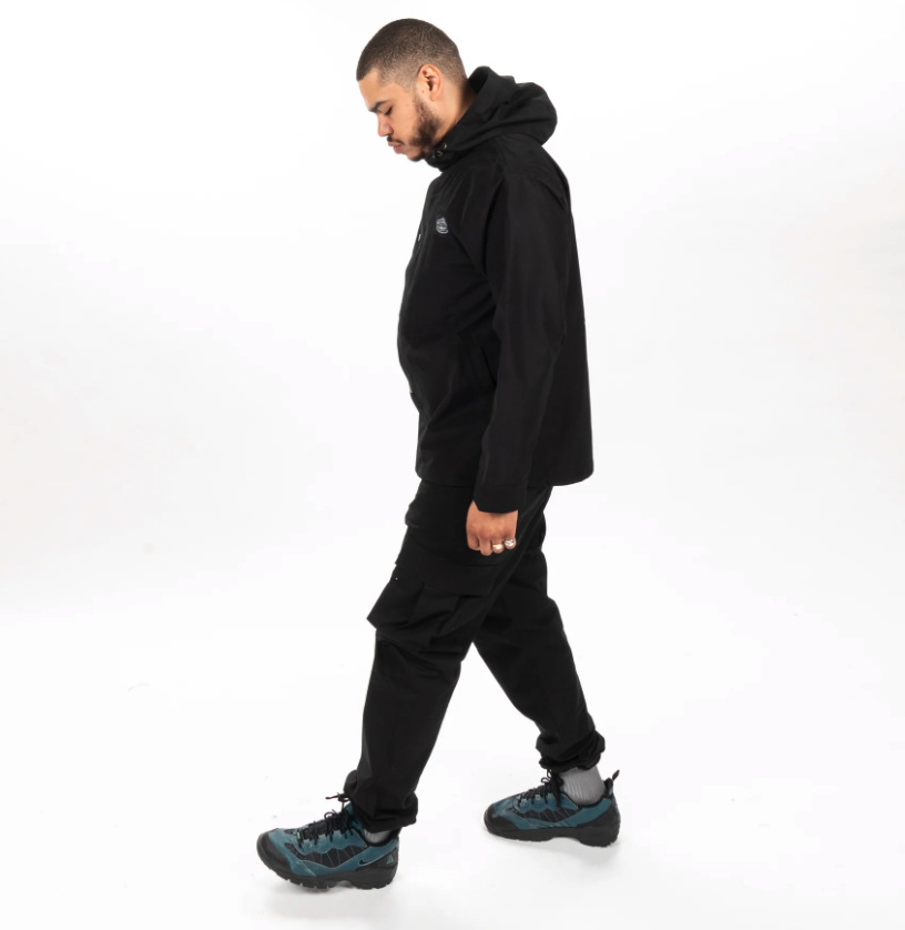 A man wearing an all-black Poler outfit feating a winter jacket and pants