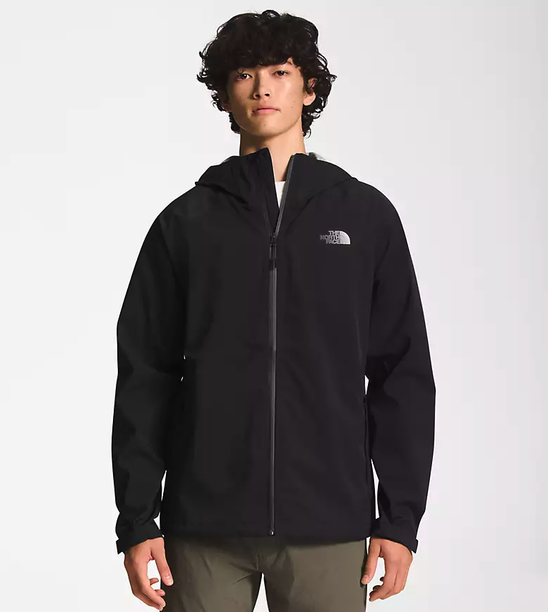 A man wearing a black North Face winter jacket and green pants