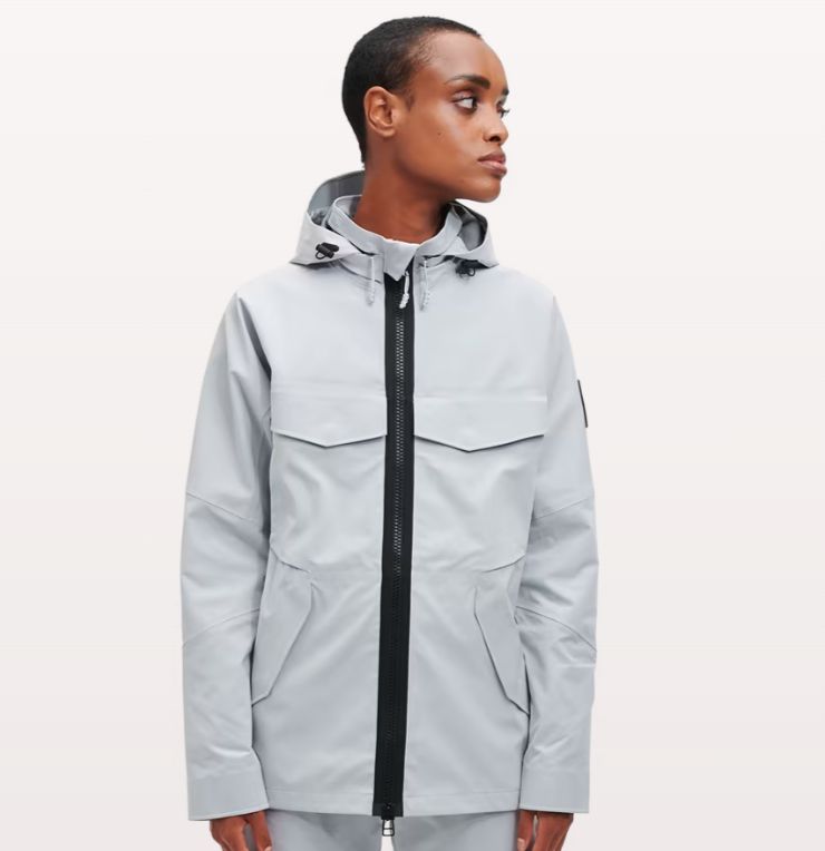A woman wearing a light grey futuristic, contemporary On-Running Jacket