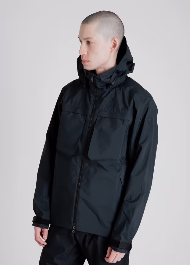 A man wearing a black Tilak winter jacket with matching pants
