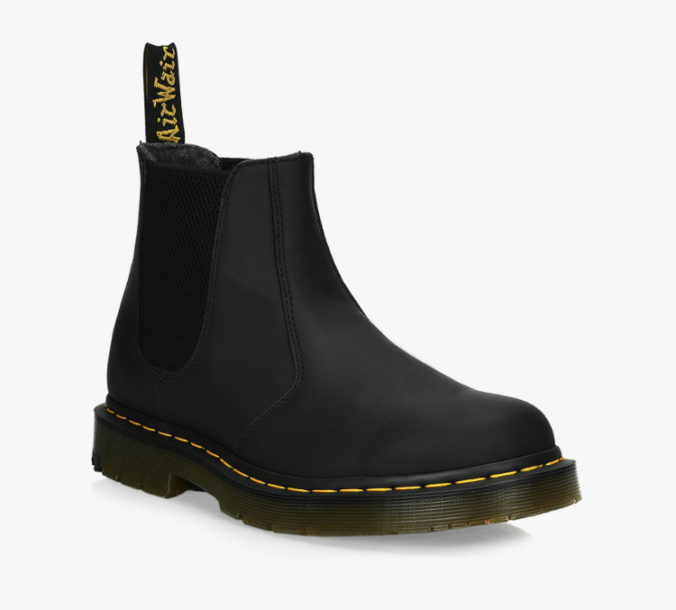 A black pair of slip-on Dr. Martens boots on a white background