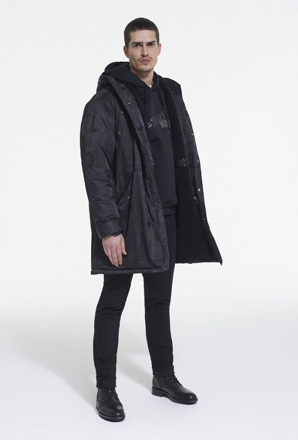 A man wearing The Kooples black jacket, with a black hoodie, pants and boots