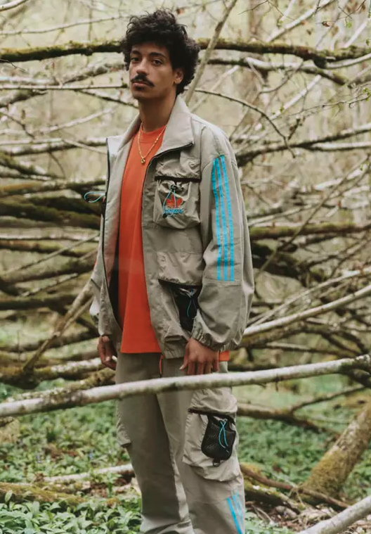 A man in the woods wearing an Adidas Palace collab outfit