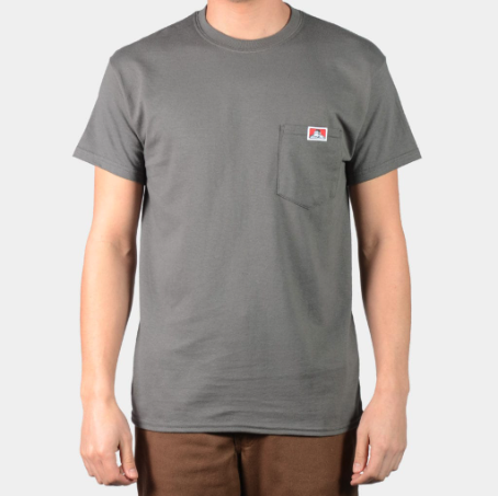 A man wearing a dark grey Ben Davis pocket t-shirt and brown pants
