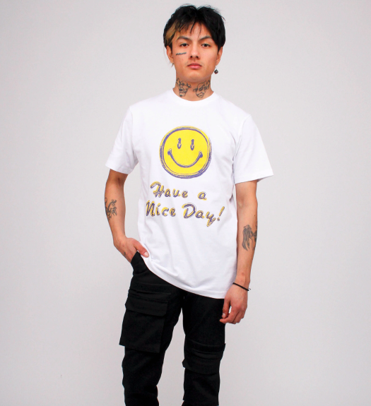 A man wearing a white smiley face Chinatown Market t-shirt and black pants