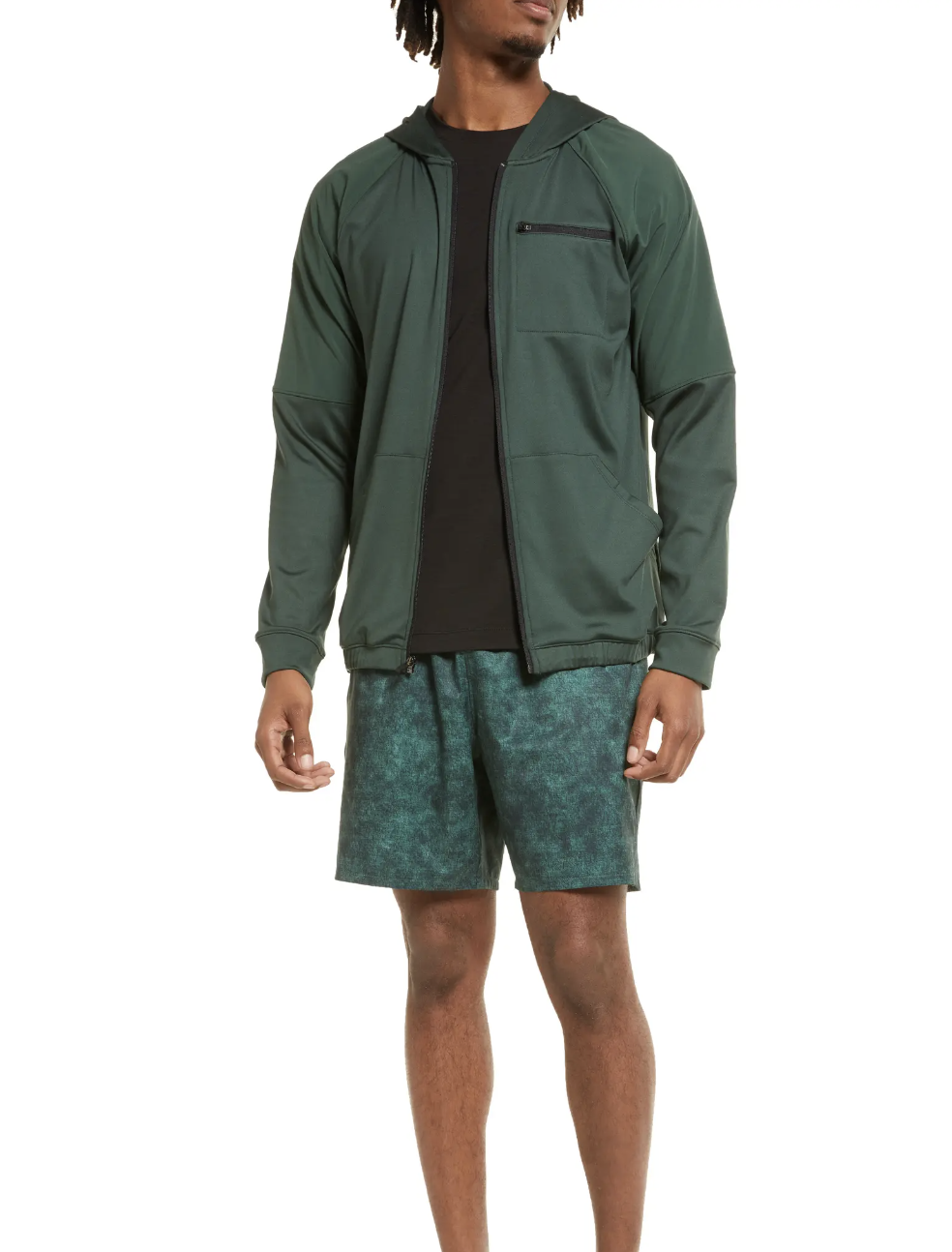 A man standing in a green Zella by Nordstrom  jacket and shorts