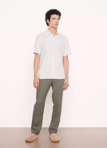 A man wearing a Vince outfit featuring a white short-sleeve button-up and green pants