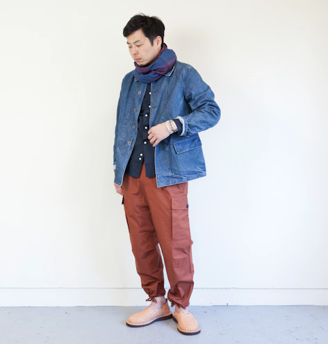 A man wearing a Chimala outfit feating a denim coat and red pants