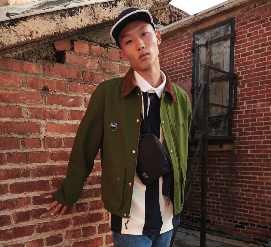 A man wearing a Levi's outfit featuring a green jacket and a white button up and jeans