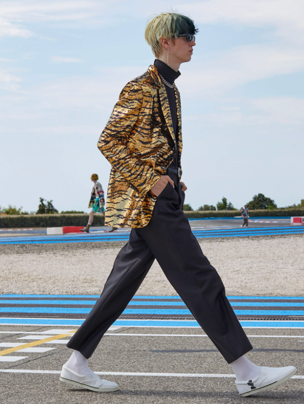 A man wearing a Celine cheetah print jacket and black pants
