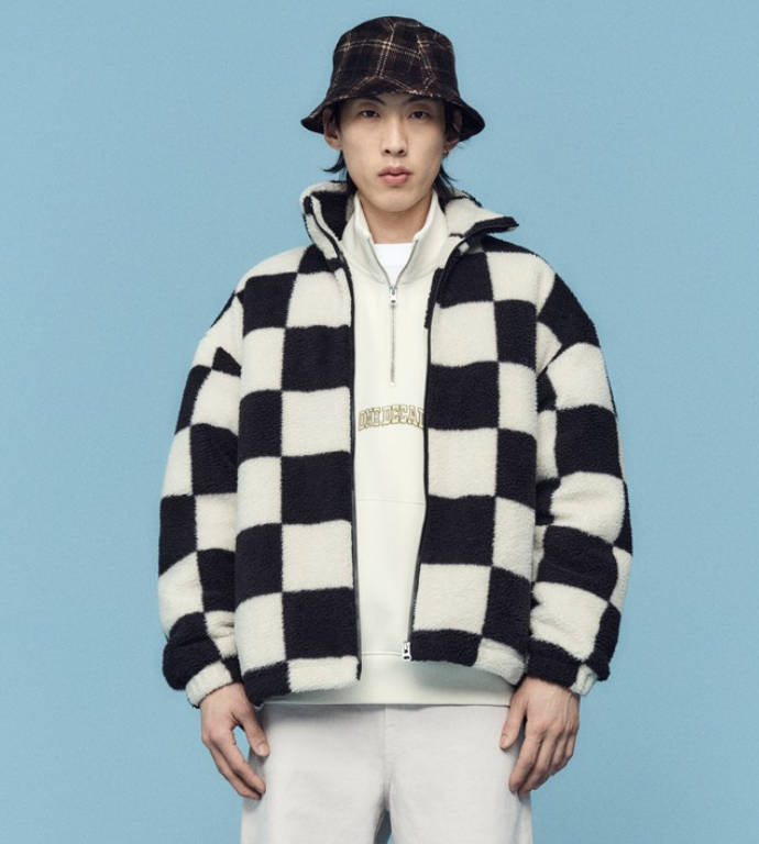 A man wearing a checkered H&M fleece jacket with a plaid bucket hat