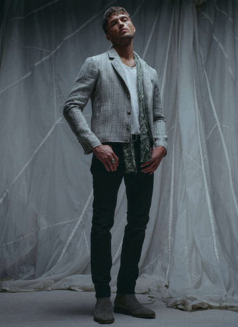 A man wearing a John Vavatos grey blazer with black pants