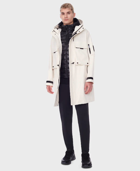 A man wearing a RudSak white winter jacket with a black puffy jacket underneath