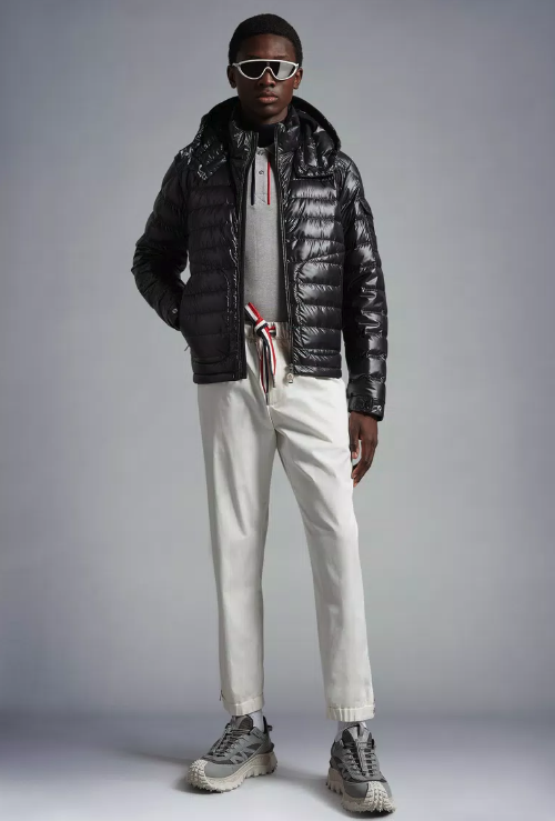 A man wearing a futuristic Moncler outfit featuring the patented puffy black jacket