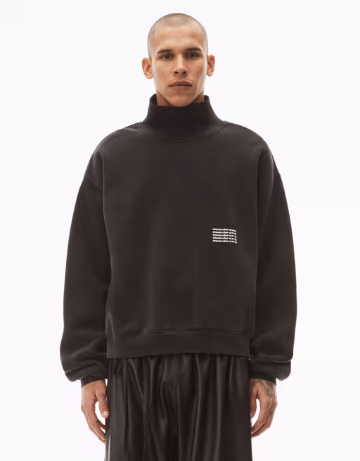 A man wearing an Alexander Wang logo fleece with black pants