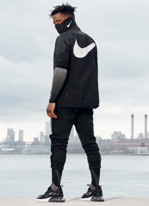 A man wearing a nike running outfit in all black