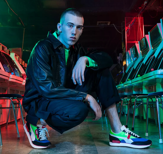 A man wearing a colorful glow in the dark Puma outfit with matching shoes