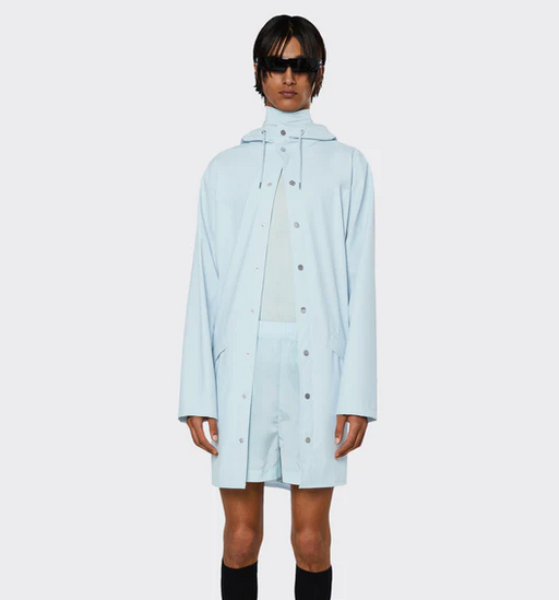 A man wearing a baby blue Rains jacket with matching shorts