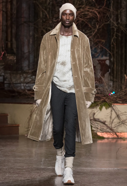 A man wearing a long brown John Varvatos jacket with black pants