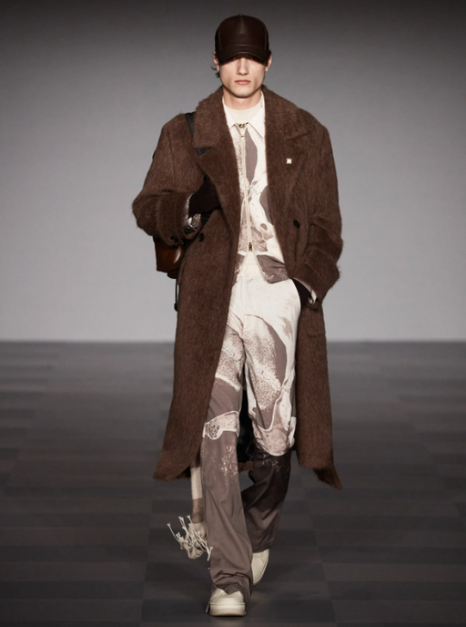 A man wearing a Amiri brown trenchcoat and futuristic suit
