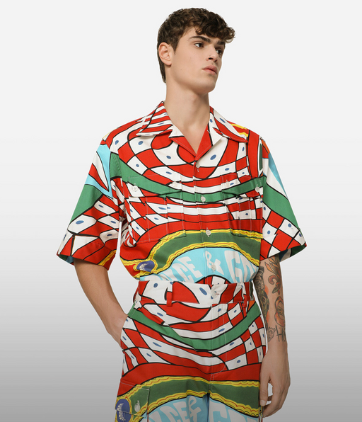 A man wearing a colorful Dolce & Gabanna button up with matching pants