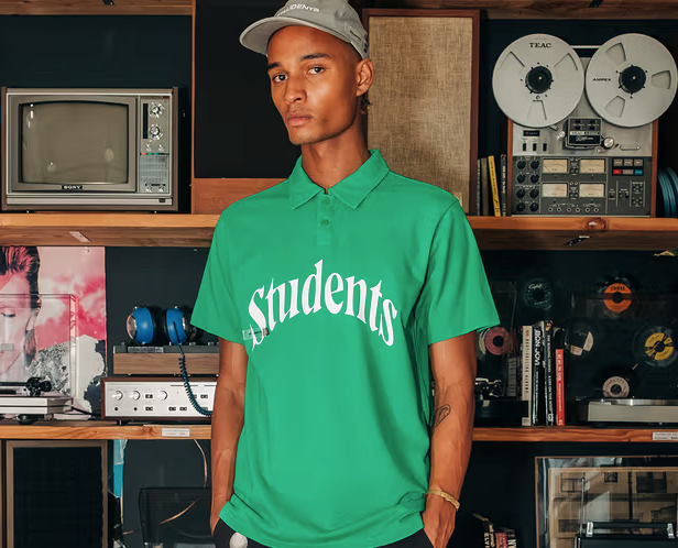 A man wearing a Students Golf green Golf shirt and grey hat