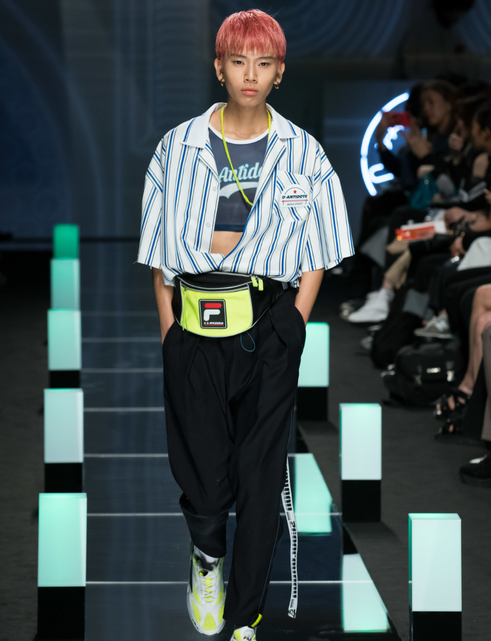 A man wearing a striped D-antidote button up with a fanny pack