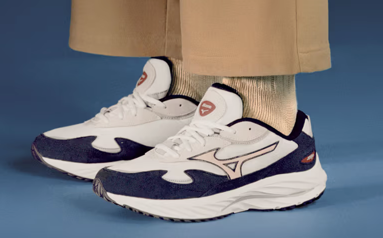 A man wearing a white and navy blue Mizuno runners