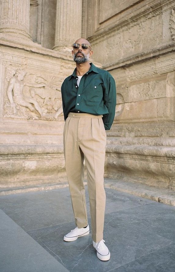 A man wearing a Shein green button up and khaki pants