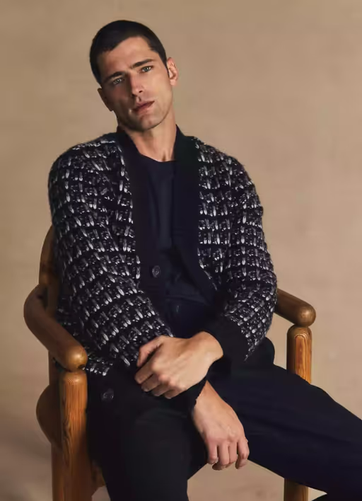 A man wearing a Vince cardigan with a black shirt and pants