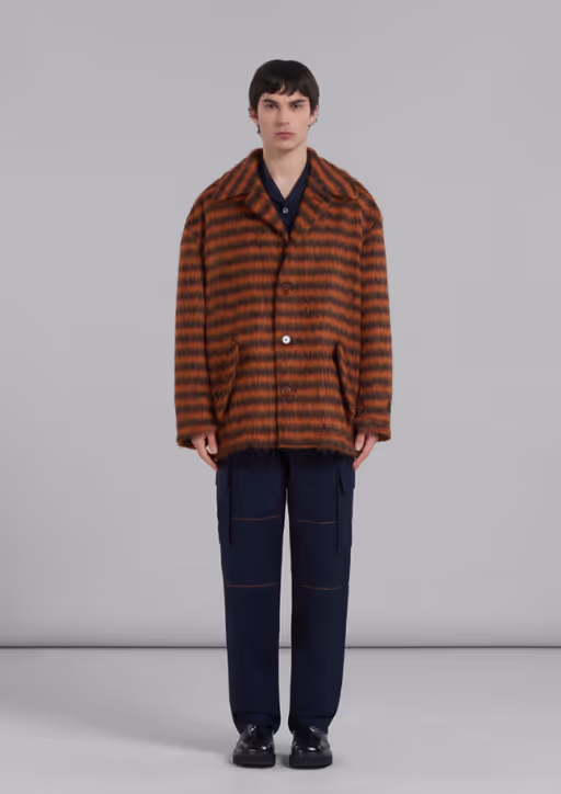 A man wearing a brown striped fleece overcoat by Marni with black pants