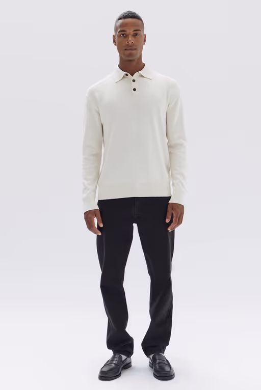 A man wearing a long sleeve white Assembly Label shirt and black pants