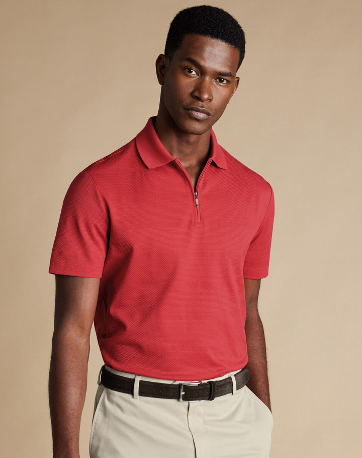 A man wearing popcorn textured tyrwhitt cool zip-neck stripe polo by Charles Tywhitt