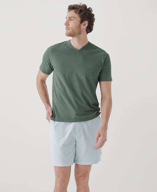 A man wearing a PACT dark forest color featherweight slub v-neck tee