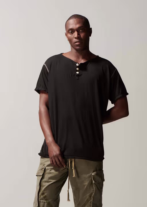 A man wearing Greg Lauren black short sleeve henley black t-shirt