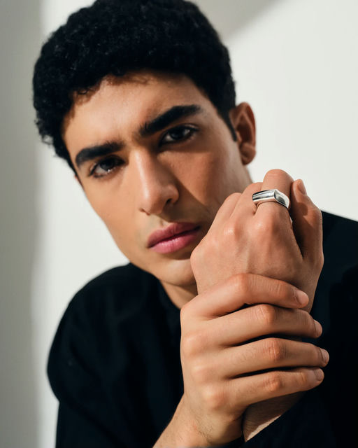 A man wearing Tom Wood crest ring
