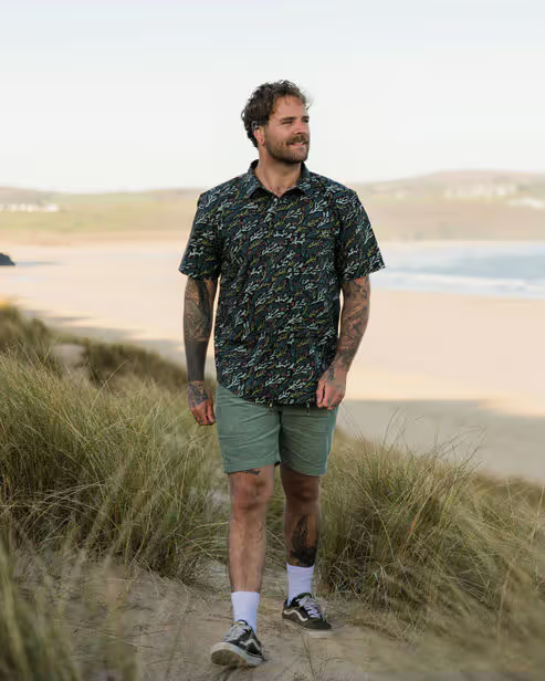A man wearing passenger ocean current black way ripstop short sleeve shirt